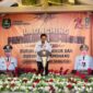 Kepala Dinsos P3A Kabupaten Sumenep Dr. R. Abd. Rahman Riadi SE MM Saat Membacakan Laporan dilaunching Penyaluran Bantuan Program BLT DBHCHT Tahun 2026 di Kecamatan Lenteng 