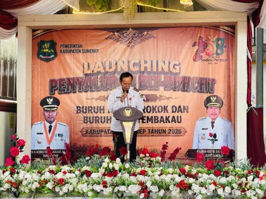 Kepala Dinsos P3A Kabupaten Sumenep Dr. R. Abd. Rahman Riadi SE MM Saat Membacakan Laporan dilaunching Penyaluran Bantuan Program BLT DBHCHT Tahun 2026 di Kecamatan Lenteng 