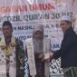 Direktur Rumah Khotmil Qur'an, Dr. Naghfir, S.H.I., S.H., M.Kn., menyerahkan uang pembinaan kepada wisudawan terbaik penghafal Al-Qur'an dalam Wisuda Tahfidz Pondok Tahfidzul Qur'an Maslahatul Hidayah, Kecamatan Bluto, Kabupaten Sumenep.