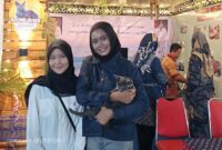 Salah satu Pengunjung Saat Memeluk Kucing Khas Pulau Raas Kucing Busok di Stand Kecamatan Raas 
