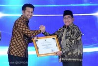 Wabup KH Imam Hasyim SH Saat Menerima Penghargaan Tiga kategori tersebut yakni Wakaf, Keuangan Mikro Syariah, serta Inklusi Keuangan Syariah Pemerintah Daerah dari Wagub Jatim Emil Elestianto Dardak di Surabaya, Minggu (27/9/2026)